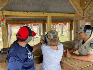 Instructor helping woman in white shirt