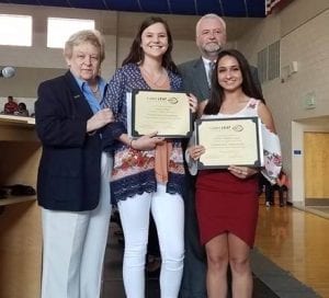 Lindsay Wood and Yaritza Aguilera are pictured with their Golden LEAF Scholarships, presented to them from Pender County Commission Chairman George Brown and Carolyn Justice